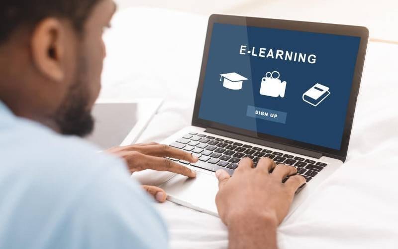 A man accesing a virtual lecture on his laptop